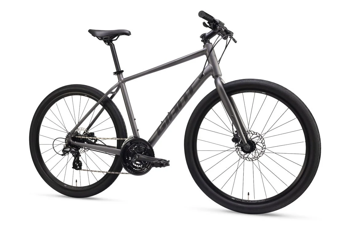 白い背景に置かれた、GIANT製のグレーのクロスバイクです