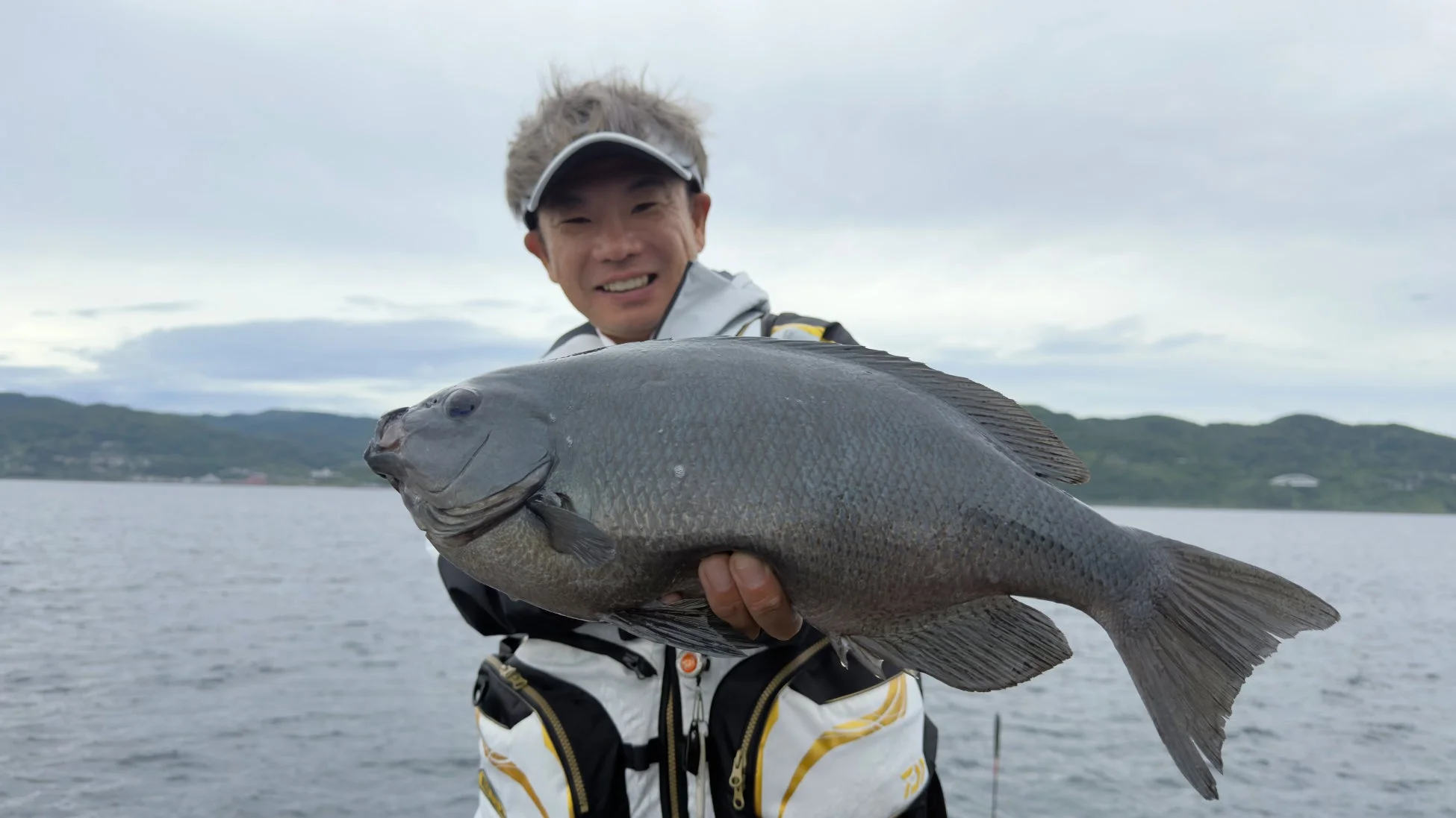 釣り上げたクチブトグレを披露する田中貴氏