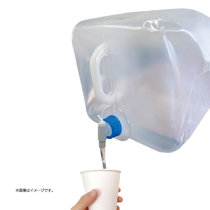 透明な折りたたみ式ウォータータンクから、コックを使って紙コップに水を注いでいる様子です。