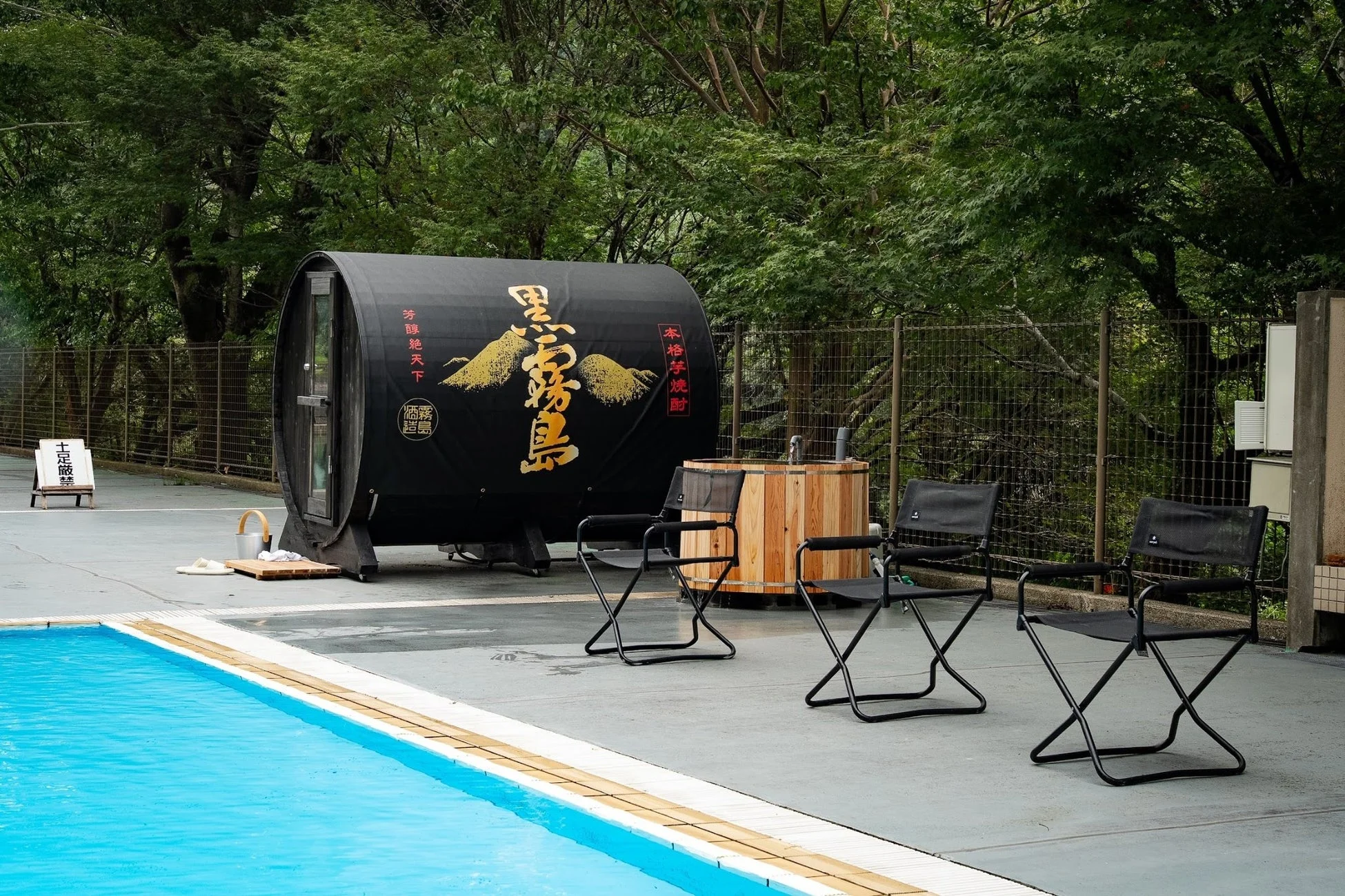 プールサイドの樽型サウナと木製の水風呂